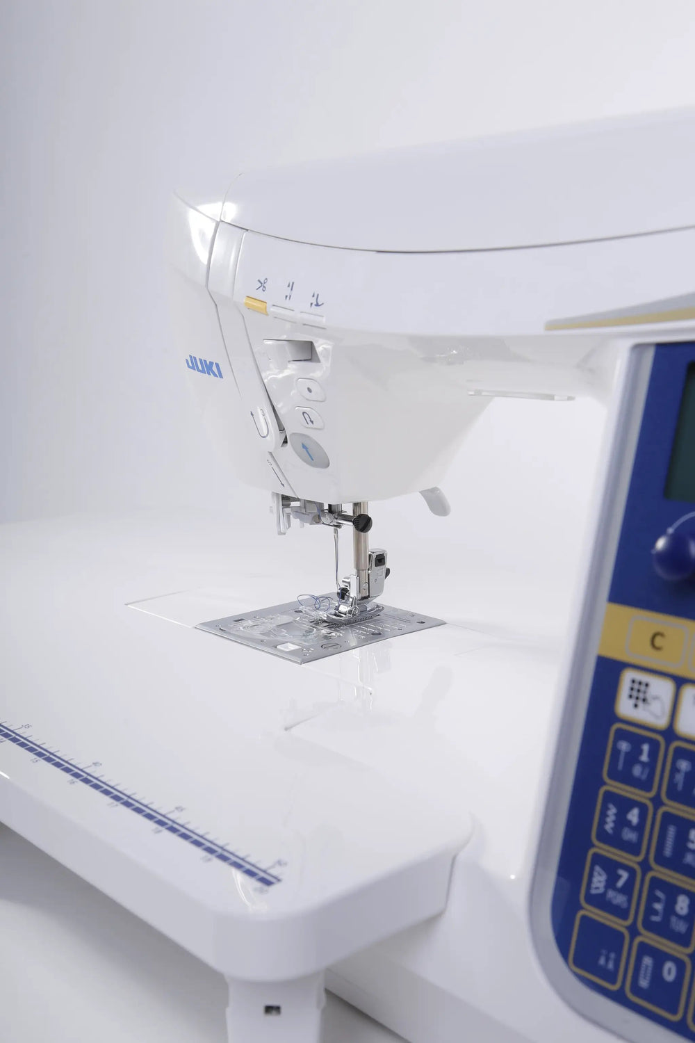 Juki HZL-DX7 computerized sewing machine, white body with blue control panel.