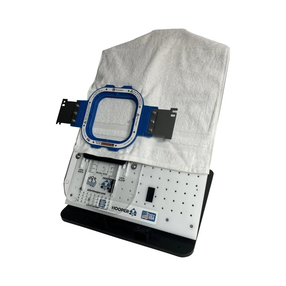 Hooper One + Leveler Pro Plus hoop brackets on a Tex Inc embroidery hooping station, blue mounting ring.