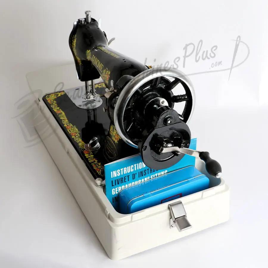Janome 131HDL hand-crank sewing machine head in black with gold detailing on a white base, blue manuals visible