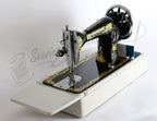 Janome 131HDL hand-crank sewing machine with ornate black body and gold trim on a white extendable table.
