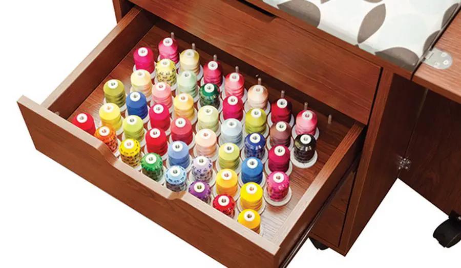 Inspira Inspiration Caddy sewing cabinet in teak with an open drawer filled with colorful thread spools