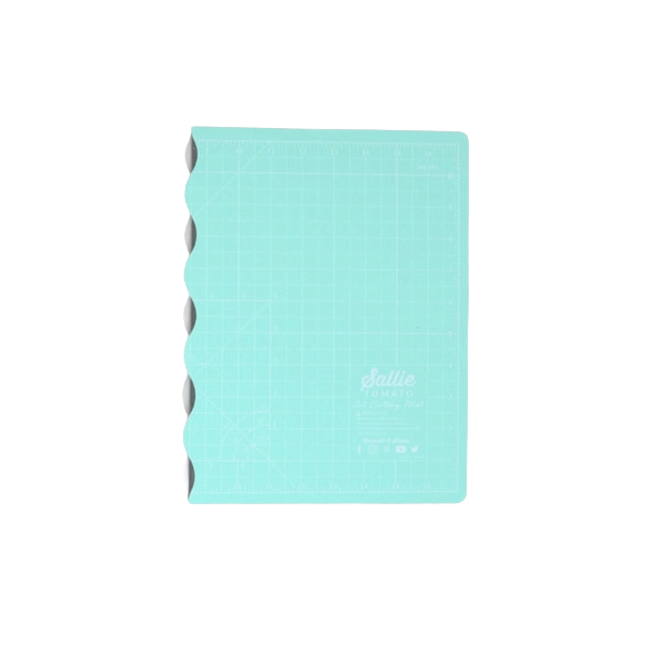 Sallie Tomato A3 foldable cutting mat in turquoise with scalloped edge.