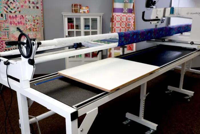 Handi Quilter Multi-Use Board Kit HQ quilting frame accessory on a white frame with fabric and sewing machine visible