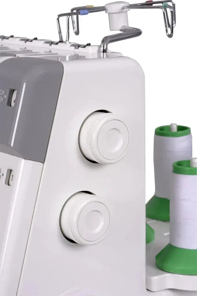 Janome MyLock 654D serger with white body and two white thread spools on green bases.