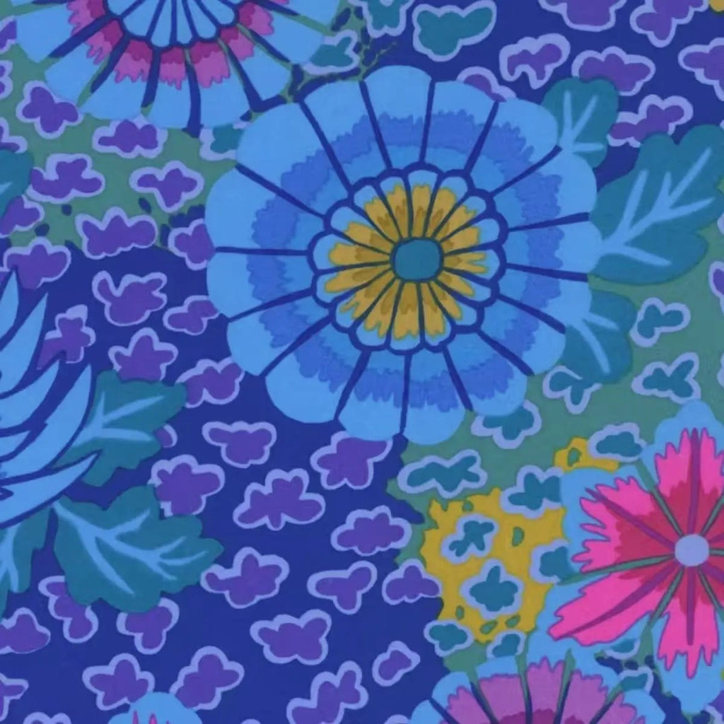 Dream Blue quilting cotton fabric with vibrant pink, purple, mustard, aqua, and blue flowers on a patterned blue background.