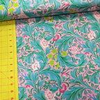 Leicester Aqua quilting cotton fabric showing aqua foliage and colorful floral motifs with ruler for scale.