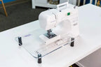 Handi Quilter Extension Table HQ Stitch 210 on clear acrylic top with ruler grid and black feet.
