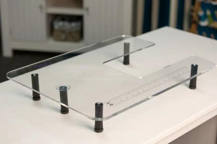 Extension table by Handi Quilter for HQ Stitch 510/610; clear acrylic with built-in ruler.