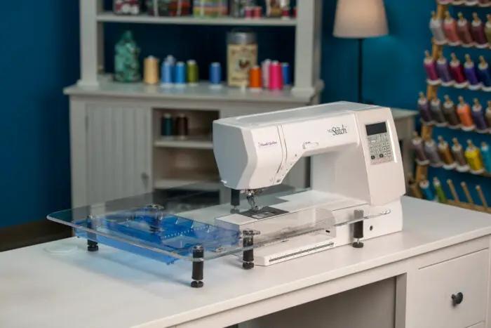 Extension table for Handi Quilter HQ Stitch 710 sewing machine on blue acrylic surface