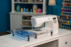 Extension table for Handi Quilter HQ Stitch 710 sewing machine on blue acrylic surface