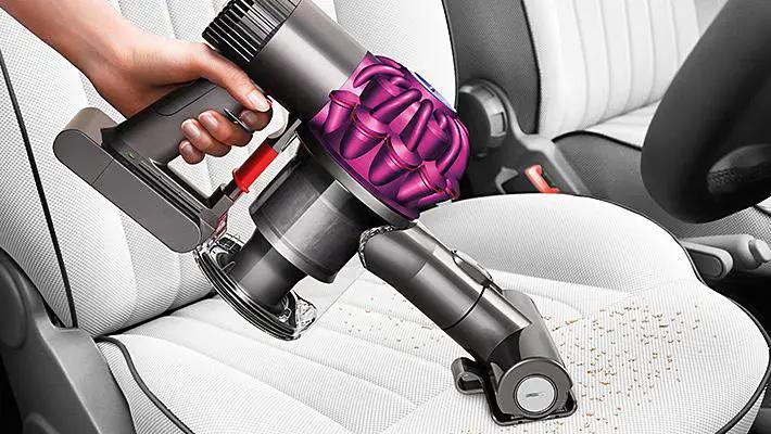 Dyson V6 Motorhead Vacuum; cordless handheld with purple cyclone cleaning car seats