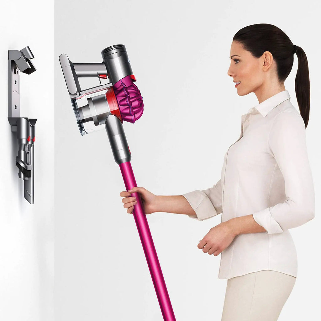 Dyson V7 Motorhead cordless vacuum with pink wand, shown beside a wall dock.