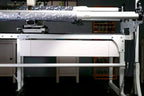 HQ Secret Drawer, Gallery quilting frame accessory on a white frame with fabric bolts.