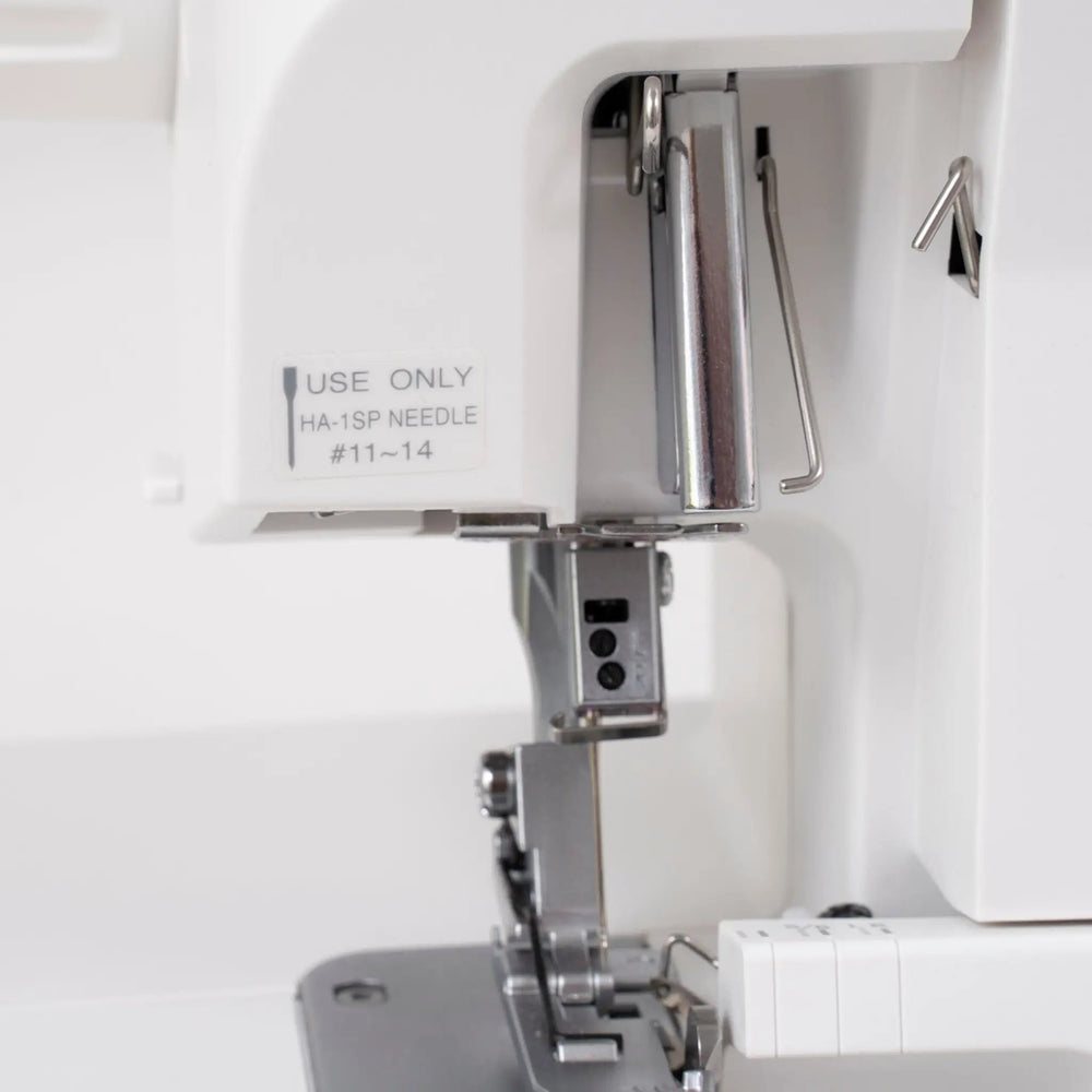 Janome SewSwitch 30 sewing & overlocker combo machine interior view with white housing and metal presser foot