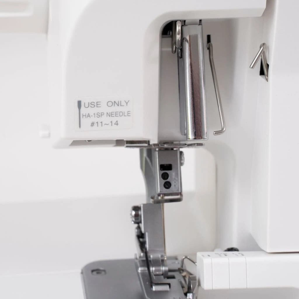 Janome SewSwitch 30 sewing & overlocker combo machine interior view with white housing and metal presser foot