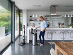 Dyson Cinetic Big Ball Animal + Allergy vacuum with stainless steel canister in a modern kitchen; two Dyson vacuums shown.