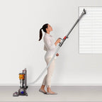 Dyson Small Ball Multifloor UP15MF vacuum with long wand and orange cyclone; woman in white using it