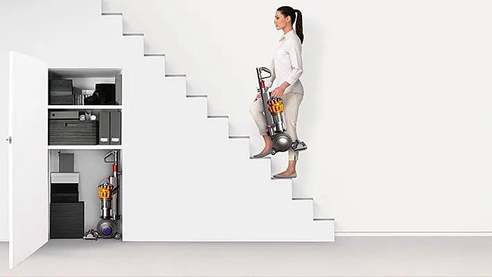 Dyson Small Ball Multifloor vacuum carried up stairs, gray with orange accents