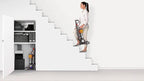 Dyson Small Ball Multifloor vacuum carried up stairs, gray with orange accents