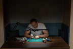 Lumi Task Lamp Satin Black (Limited Edition) by Daylight, adjustable desk lamp on a wooden table with model figures.