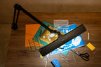 Lumi Task Lamp Satin Black Limited Edition by Daylight on a wooden desk with craft supplies