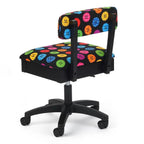 Sewing chair with black frame, five-wheel base, and colorful button-pattern upholstery.
