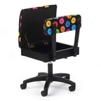 Sewing cabinet set by Kangaroo Sewing Furniture on a wheeled chair base with colorful button-pattern upholstery