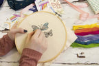 Threaders Embroidery Transfer Sheets - Spring; embroidery in progress in a wooden hoop with colorful rainbow threads.