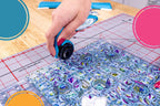 Grace 28mm TrueCut My Comfort Rotary Cutter in blue cutting fabric on a grid ruler
