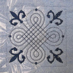 Machine embroidery design on light blue fabric with blue thread detail.