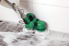 Bissell BGCC1000 dual-brush floor machine with green body and white brushes cleaning soapy tiled floor.