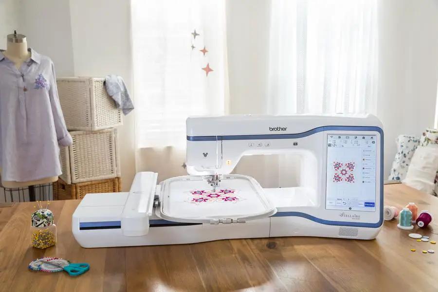Brother Stellaire Innov-is XE1 embroidery machine with touchscreen, white and blue finish, embroidery hoop.