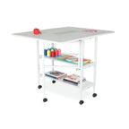 Arrow White Dixie adjustable cutting table on wheels with lower shelves.