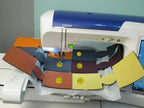 Brother sewing machine with colorful fabric swatches laid out around the needle