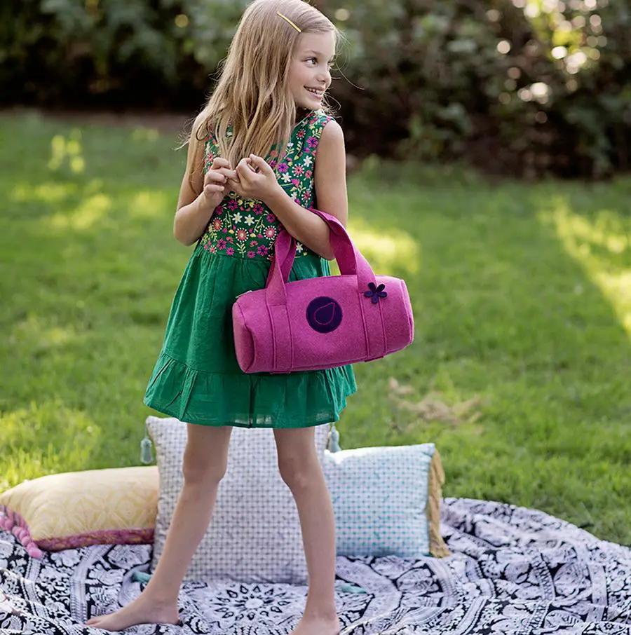 Bluefig University Learn to Sew Lil Duffle Class 300 pink fabric bag carried by girl outdoors