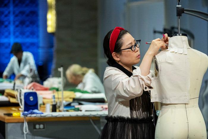 A women is designing a cloth on a dress form