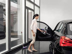 Dyson V8 Animal cordless vacuum; bottom-release dust cup, two units shown cleaning a car interior.