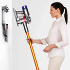 Dyson V8 Absolute vacuum cleaner with orange wand, silver body, transparent dust cup; wall dock with attachments