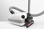 SEBO AIRBELT E3 Premium canister vacuum in Arctic White with gray hose and floor nozzle.