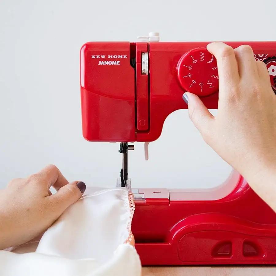 Janome Derby Line portable sewing machine in bandana blush color; hands guide white fabric under presser foot.