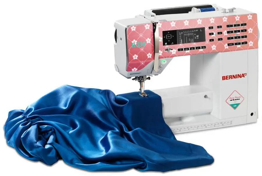 Bernina 530 sewing machine Cherry Blossom Limited Edition with white body, pink floral panel, and blue satin fabric.