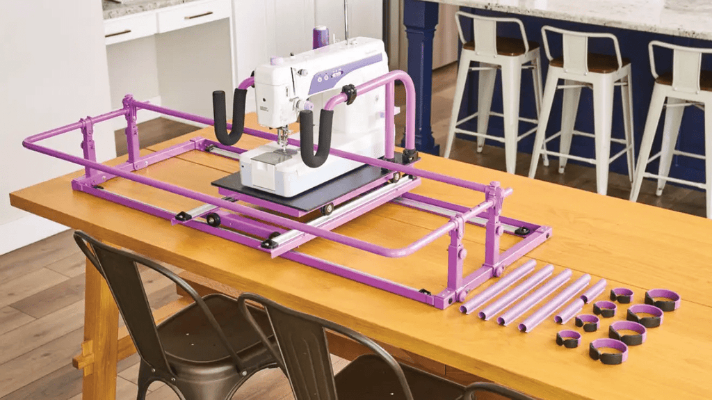 Handi Quilter FreeWay Quilt Frame on a table, purple frame with mounted sewing machine and extra tubes