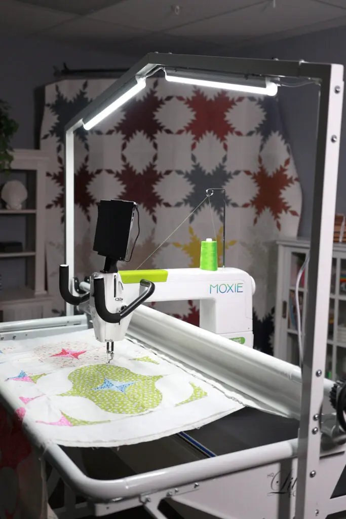 Handi Quilter HighLight 2 5' white LED lighting system mounted on a quilting frame; green thread spool and MOXIE