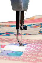 Handi Quilter Sweet Sixteen long arm quilting machine with needle and presser foot on colorful fabric