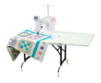 Handi Quilter Sweet Sixteen long arm quilting machine on a black metal frame with white table extension