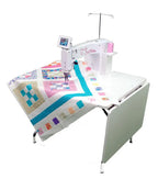 Handi Quilter Sweet Sixteen long-arm quilting machine on a sit-down frame with touchscreen display and quilt loaded.
