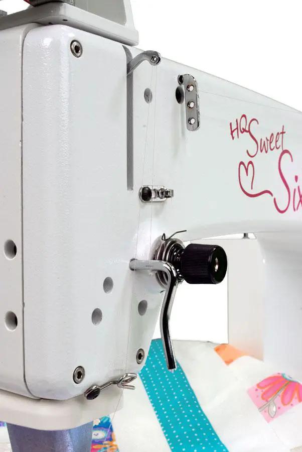 Handi Quilter Sweet Sixteen long arm quilting machine, white body with pink logo, side view.