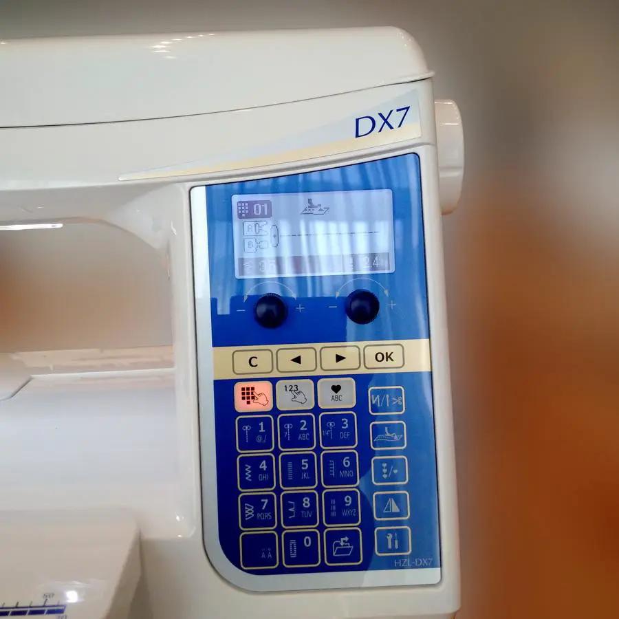 Juki HZL-DX7 sewing machine with white body and blue touchscreen control panel.