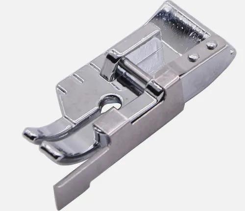 A polished silver metal 1/4" patchwork quilting foot on a plain light gray background w/ guide.