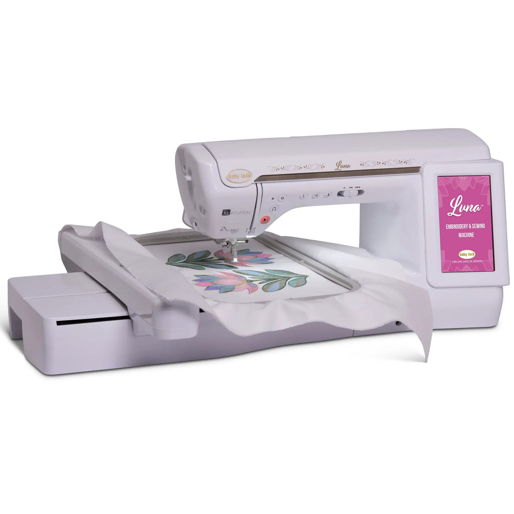 Baby Lock Luna sewing and embroidery machine; white with pink touchscreen and floral embroidery on fabric.